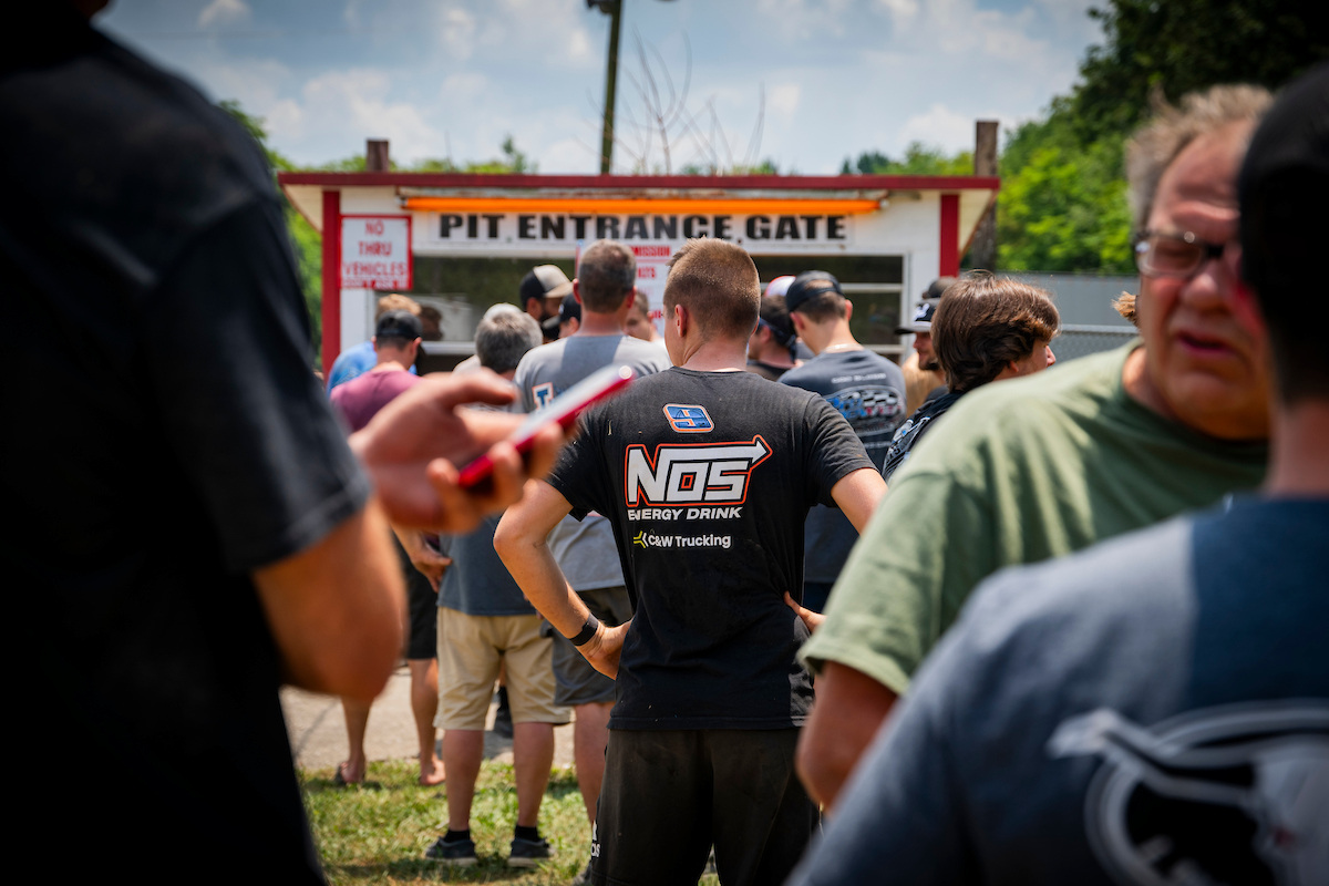 A crew member of Nick Hoffman waits at the pit gate to enter a dirt race